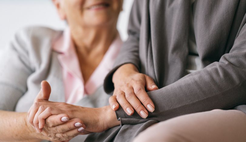 Healing Care Hospice social worker holding hospice patient hand