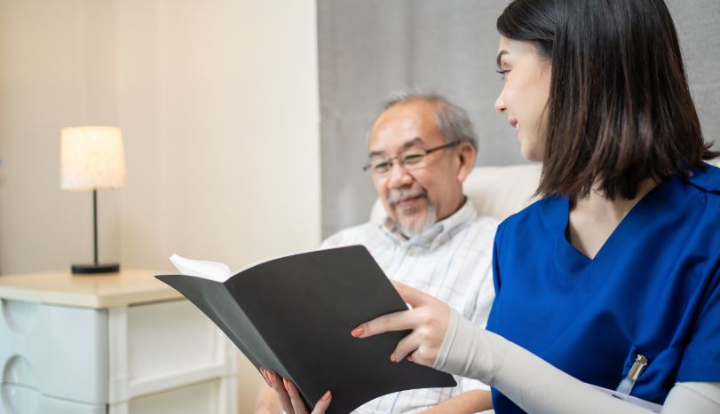 Hospice worker reading book to hospice patient at home