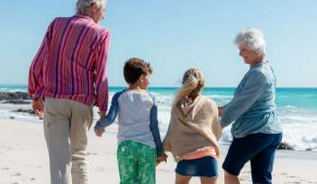 Grandparents and their grandchildren walking on los angeles beach during daytime