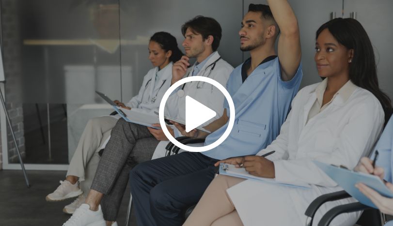 Nurses sitting in hallway listening to discussion and taking notes