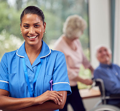 Hospice nurse smiling in front of hospice patients in background