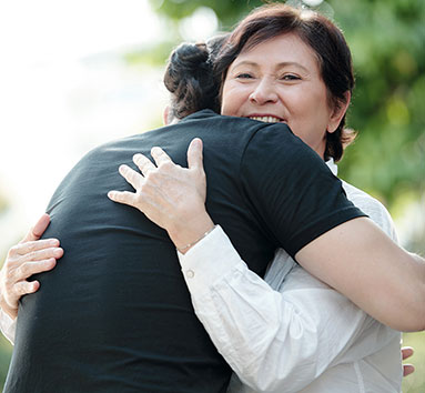 Young woman hugging hospice patient outside in park during daytime