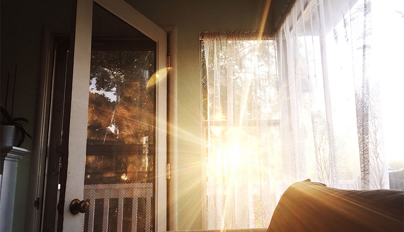 Sun shining through house door during sunset
